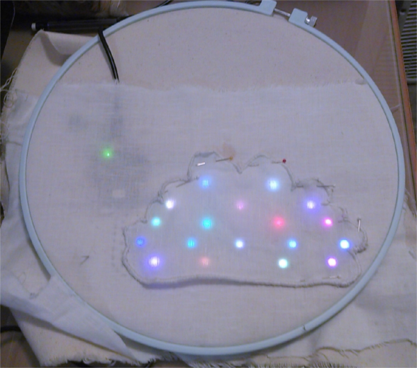 The cloud element, pinned onto the larger design, with lights lit beneath.  No diffusing elements are included, so the lights appear to be point sources inside the cloud, with large unlit regions.