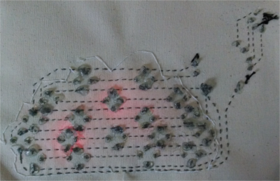 The back of the cloud design, showing hot glue blobs sealing the end of each thread.