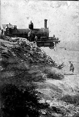 A locomotive with its nose off the edge of a cliff.